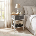 Comodino shabby chic Andres ambientato in una luminosa camera da letto con lampada e libri.