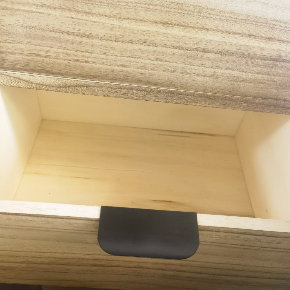 Dettaglio ravvicinato del cassetto aperto in legno chiaro con maniglia in metallo nero a contrasto.
