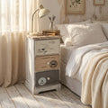 Comodino shabby chic Bartolome a tre cassetti ambientato in una camera da letto luminosa.
