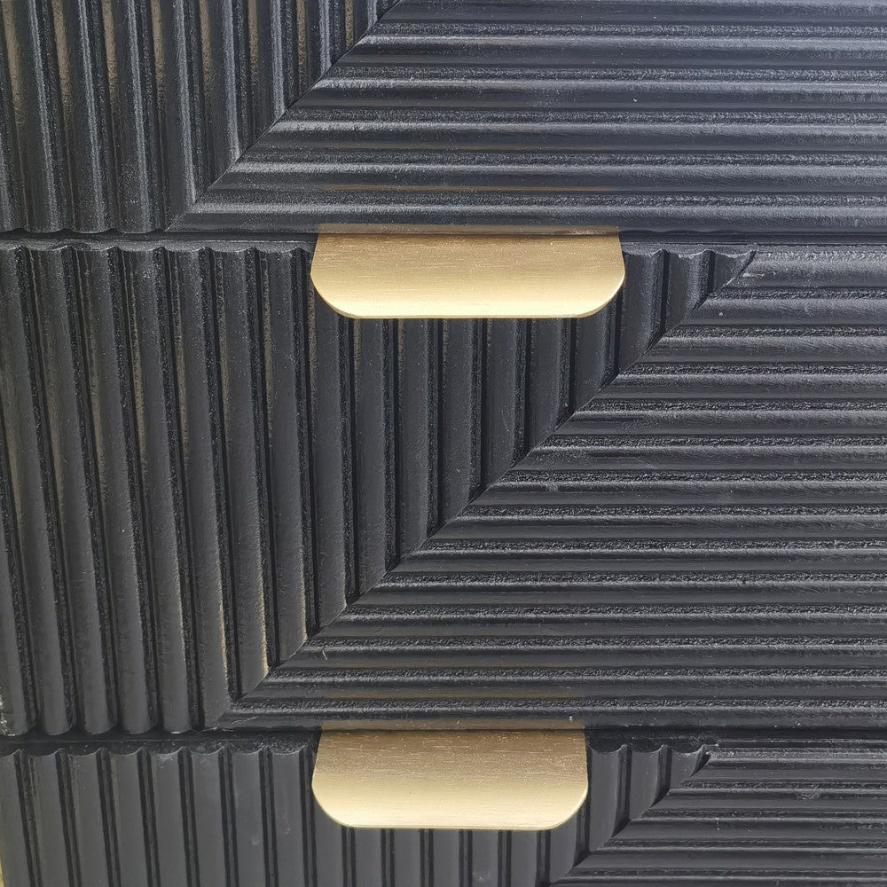 Dettaglio macro della texture a coste diagonali sui cassetti neri del comodino Asier.