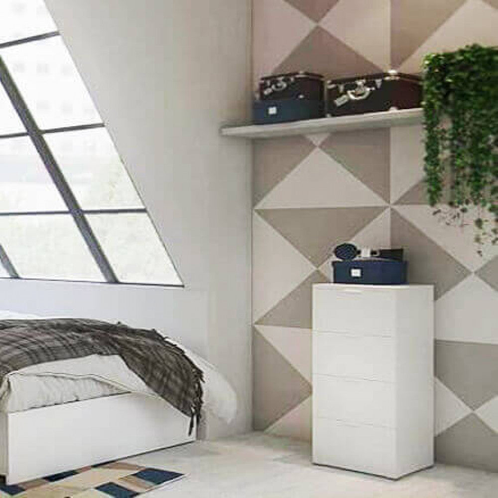 Cassettiera bianca inserita in una camera da letto moderna con carta da parati geometrica.