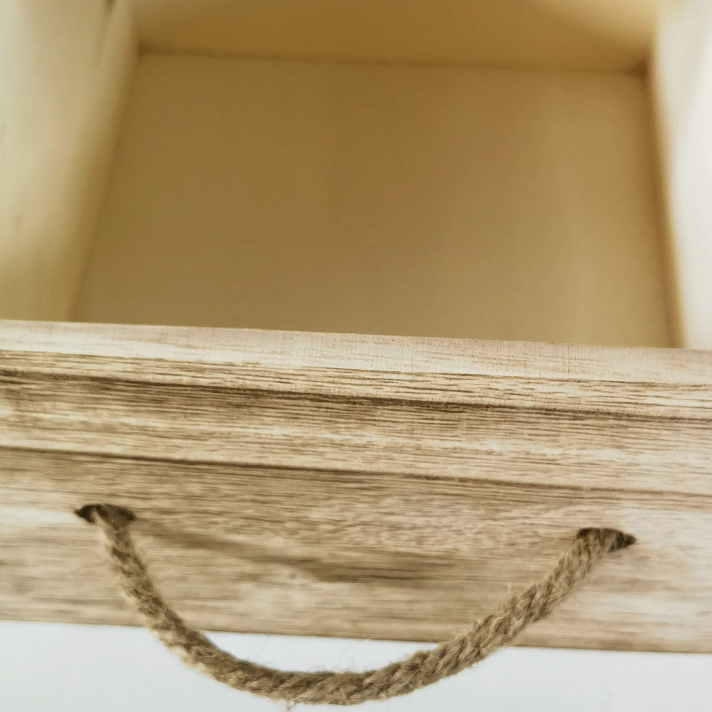 Dettaglio ravvicinato del cassetto in legno naturale del mobiletto Blas, che mostra la texture del legno e la maniglia in corda rustica.