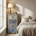 Comodino Chico a quattro cassetti in stile shabby chic, ambientato in una luminosa camera da letto accanto a una finestra.
