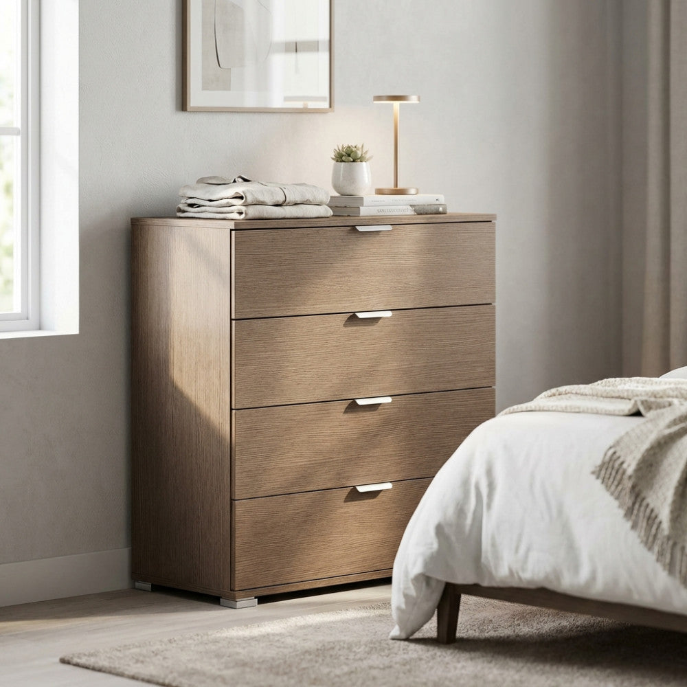 Dettaglio della cassettiera in rovere grigio con abiti piegati e una lampada di design sul piano d'appoggio.