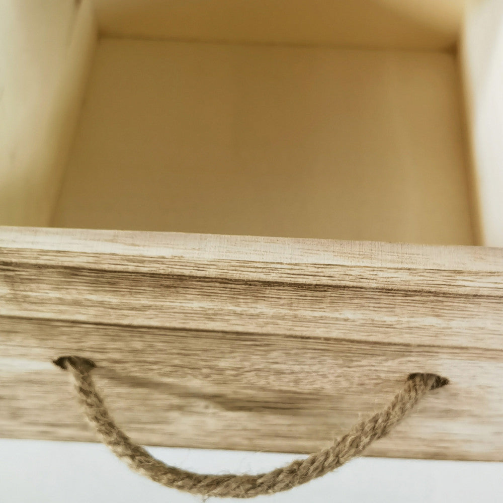 Dettaglio ravvicinato del cassetto in legno naturale con maniglia rustica in corda del mobiletto Blas.