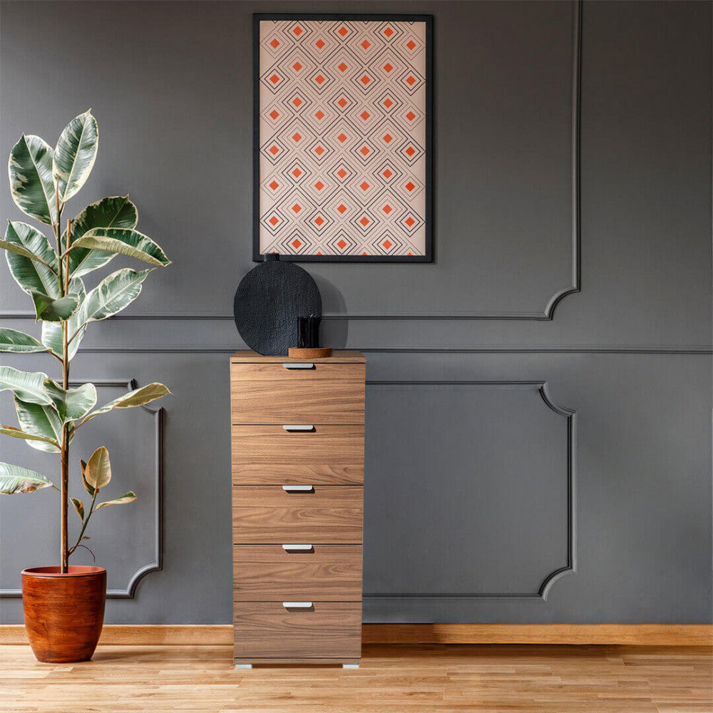 Cassettiera elegante in noce ambientata in un soggiorno con pareti grigio scuro, affiancata da una grande pianta di Ficus.
