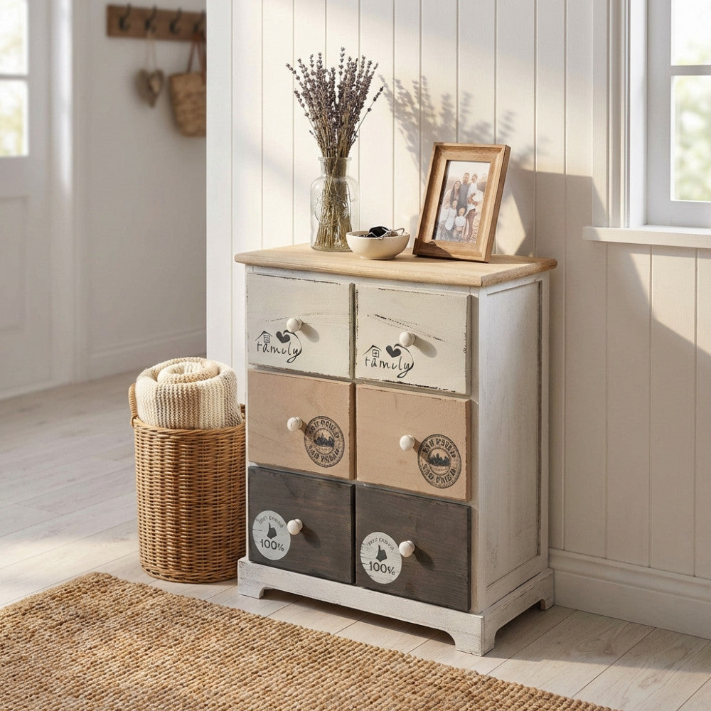 Mobiletto shabby chic Bartolome a 6 cassetti ambientato in un ingresso luminoso con cesto in vimini.