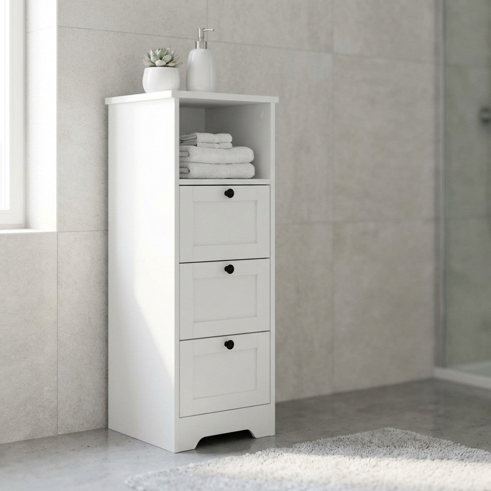 Cassettiera Aldous in legno bianco ambientata in un bagno moderno e luminoso, decorata con asciugamani e accessori.
