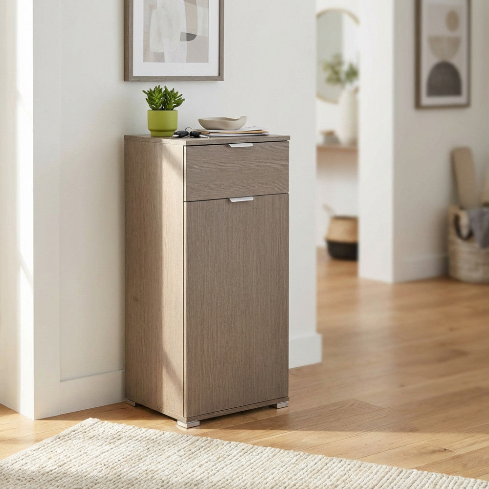 Dettaglio del mobiletto in rovere grigio con cassetto e anta chiusi, illuminato da luce naturale.