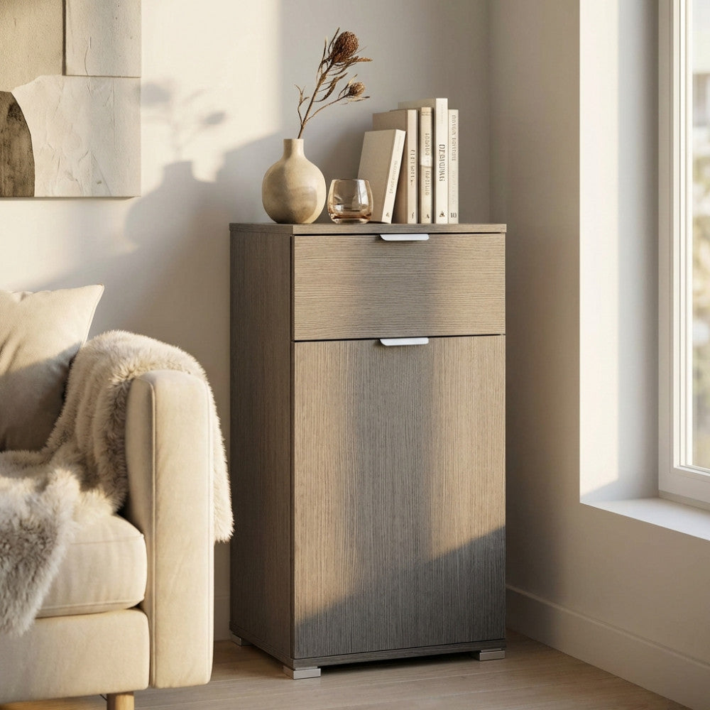 Mobiletto MR805043 in rovere grigio ambientato in un salotto luminoso accanto a un divano chiaro.