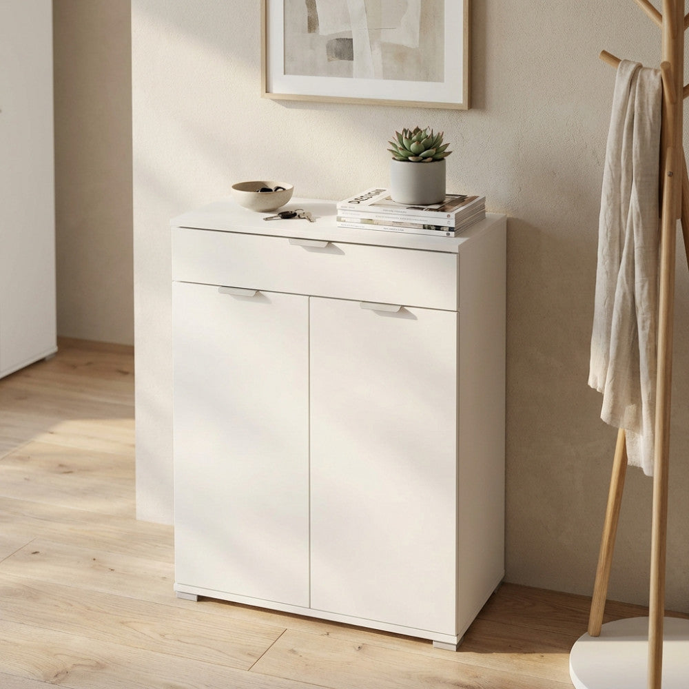 Dettaglio del mobiletto bianco in truciolare bilaminato decorato con libri e una piccola pianta.