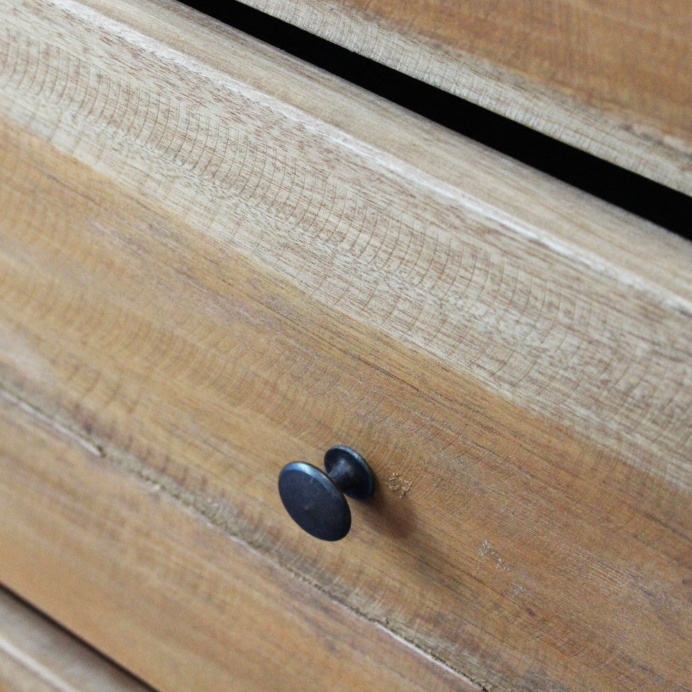 Dettaglio macro del legno massello e del pomello rotondo in metallo, che esalta la texture tattile del materiale.