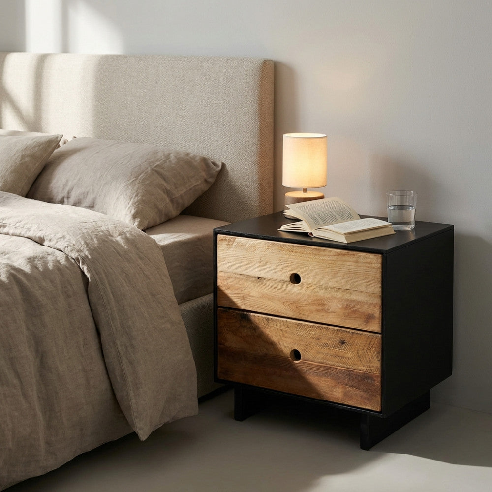Dettaglio del comodino Donny illuminato dalla luce naturale accanto a un letto in lino.