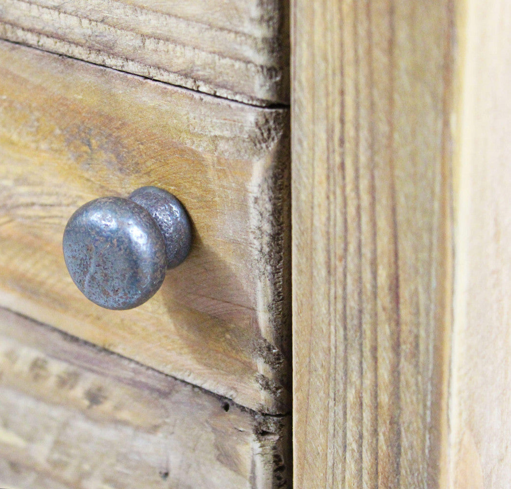 Dettaglio del pomello in metallo anticato sul cassetto del mobiletto Farran in pino riciclato.
