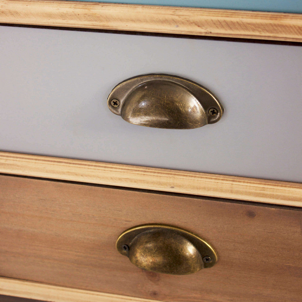 Primo piano delle maniglie a conchiglia sui cassetti azzurro e marrone, che esalta la texture liscia del legno MDF.