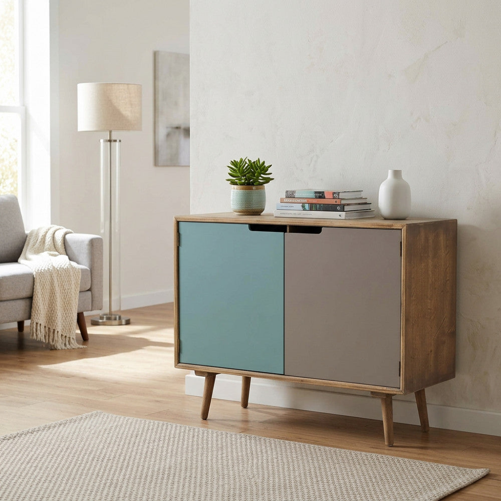 Credenza moderna Niagara in legno con ante multicolor azzurro e tortora, ambientata in un soggiorno luminoso con divano grigio.