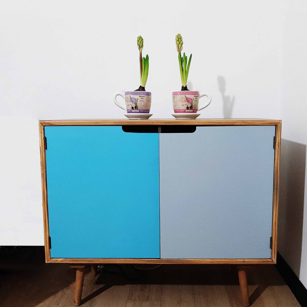 Credenza Niagara inserita in un contesto domestico intimo, decorata con due piccole piante in vaso che esaltano i toni naturali del legno.