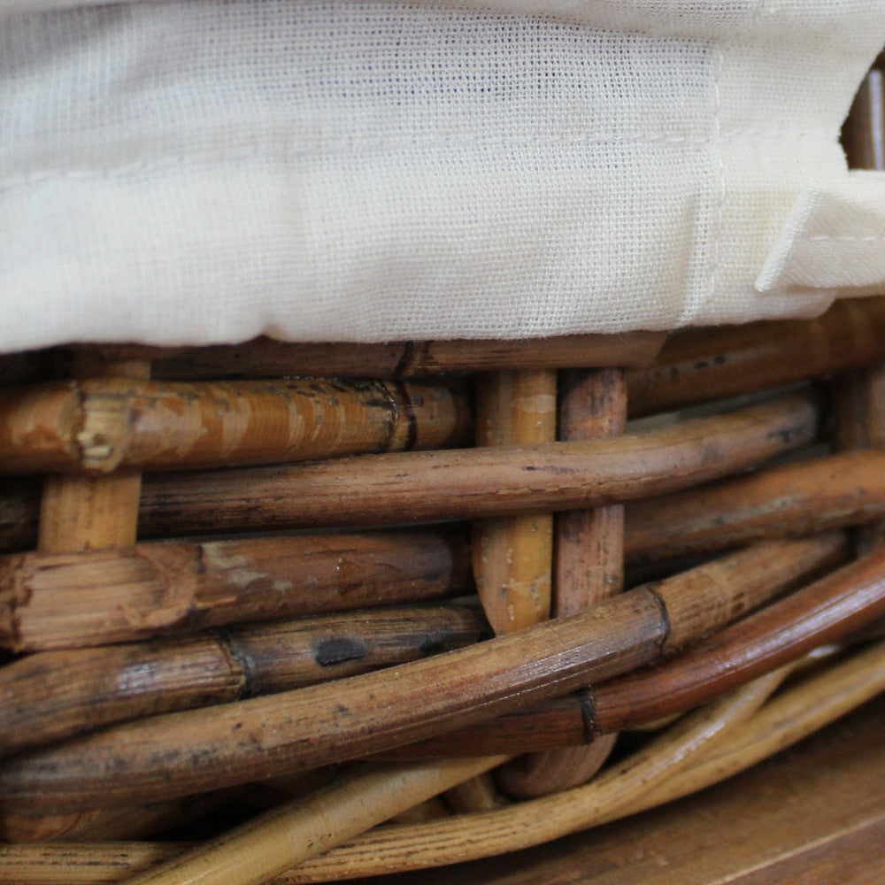 Dettaglio ravvicinato dell'intreccio in rattan naturale e della fodera in cotone bianco sfoderabile.