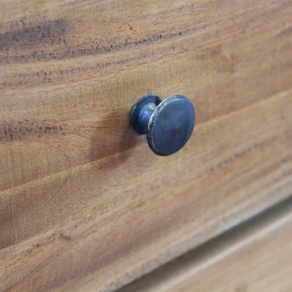 Particolare del pomello in metallo scuro dal finish anticato, applicato sul cassetto in legno riciclato.