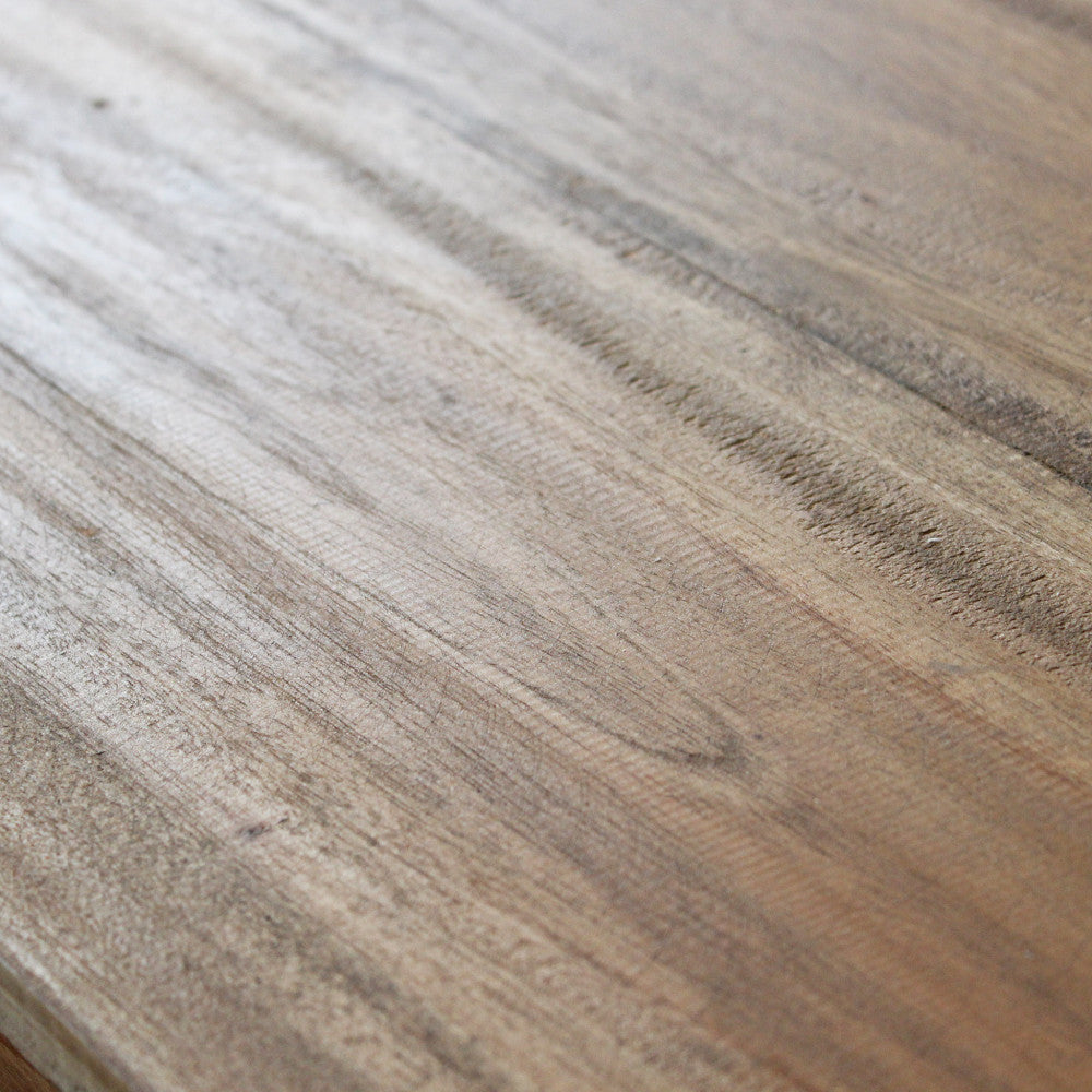 Macro sulla superficie superiore in legno riciclato, che mostra le venature naturali e la finitura materica marrone.
