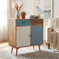 Cassettiera Surrey in legno MDF multicolor ambientata in un salotto luminoso con decorazioni floreali e tappeto intrecciato.