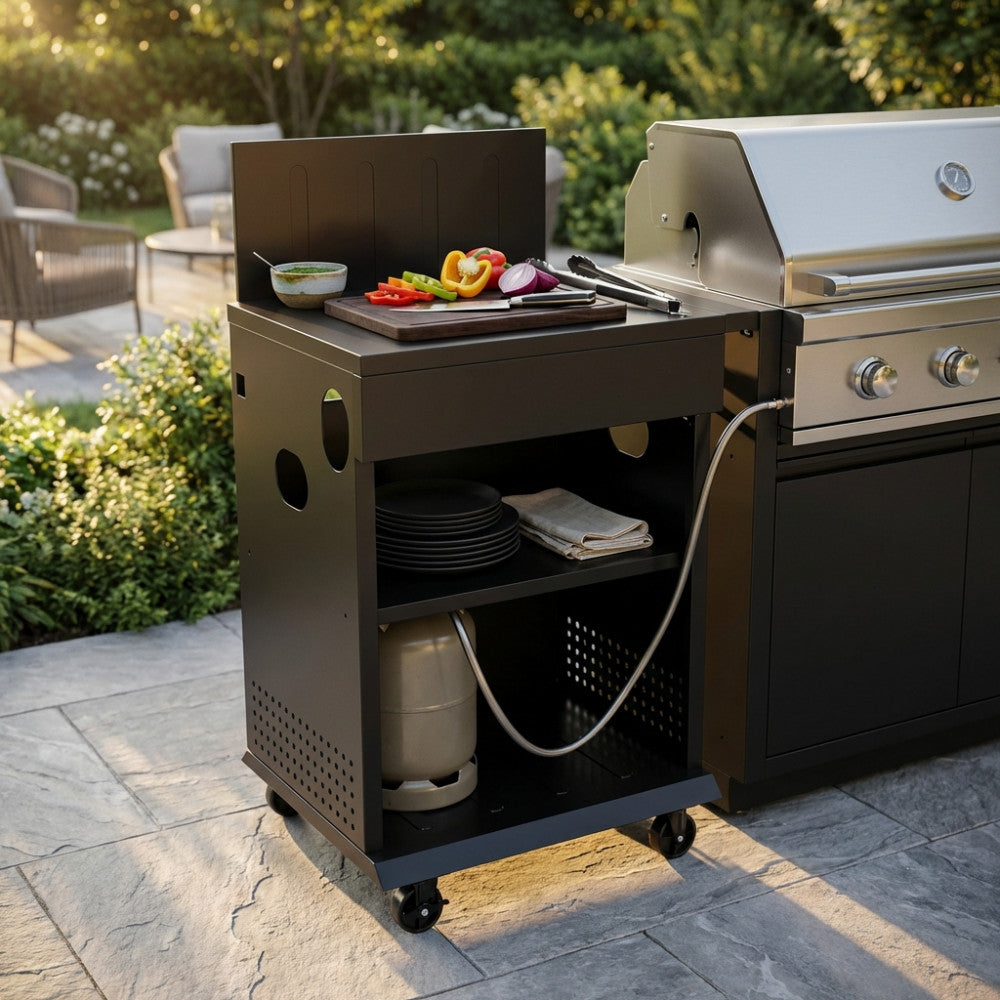 Modulo cucina esterna in metallo nero con tagliere e verdure, affiancato a un barbecue a gas in acciaio.