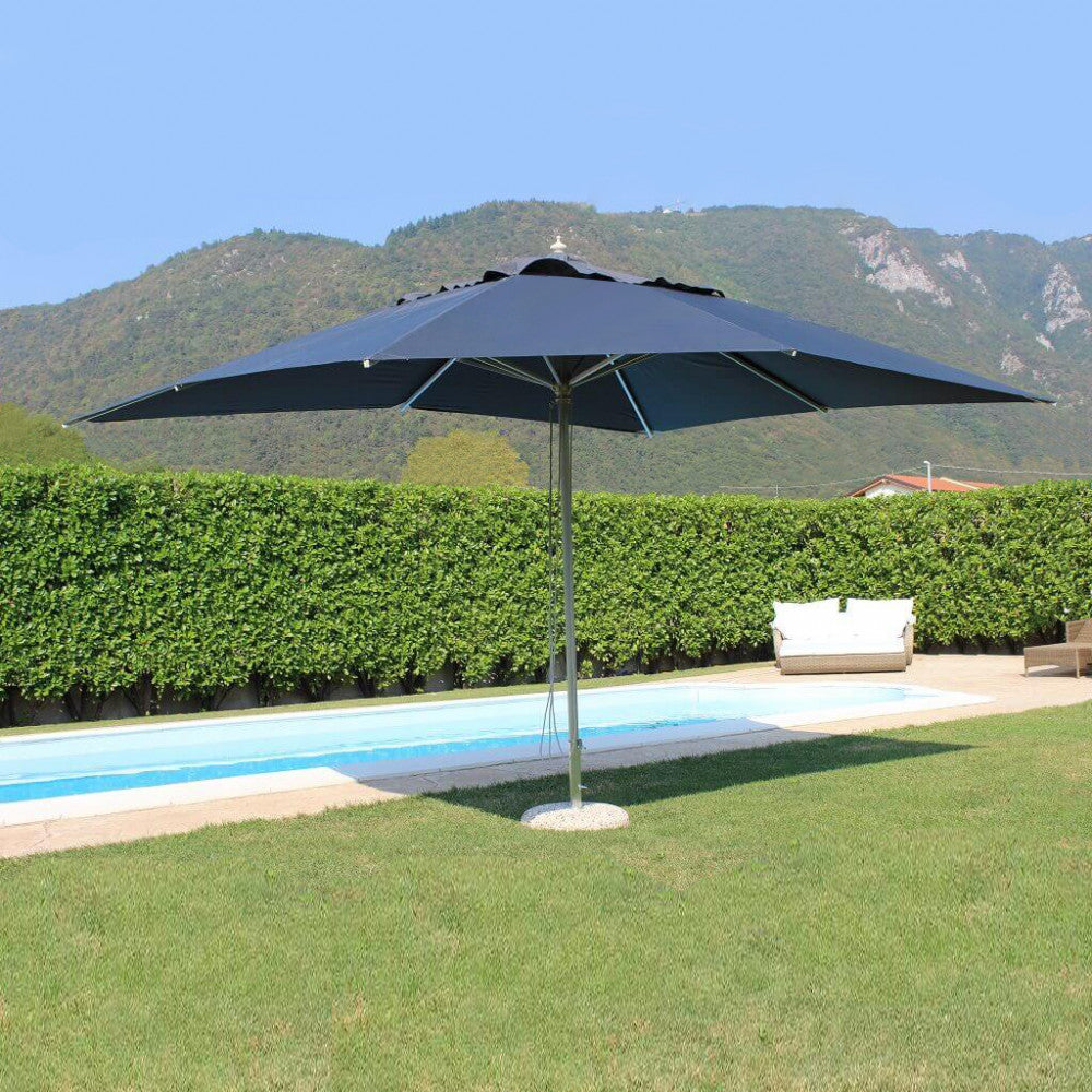 Ombrellone Andromeda grigio installato su un prato verde curato vicino a una piscina moderna, con colline sullo sfondo.
