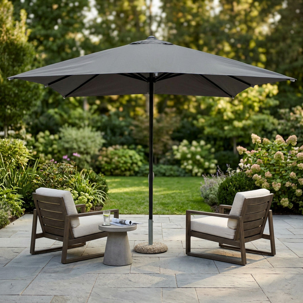 Ombrellone Brian aperto in un giardino lussuoso con due poltrone lounge.