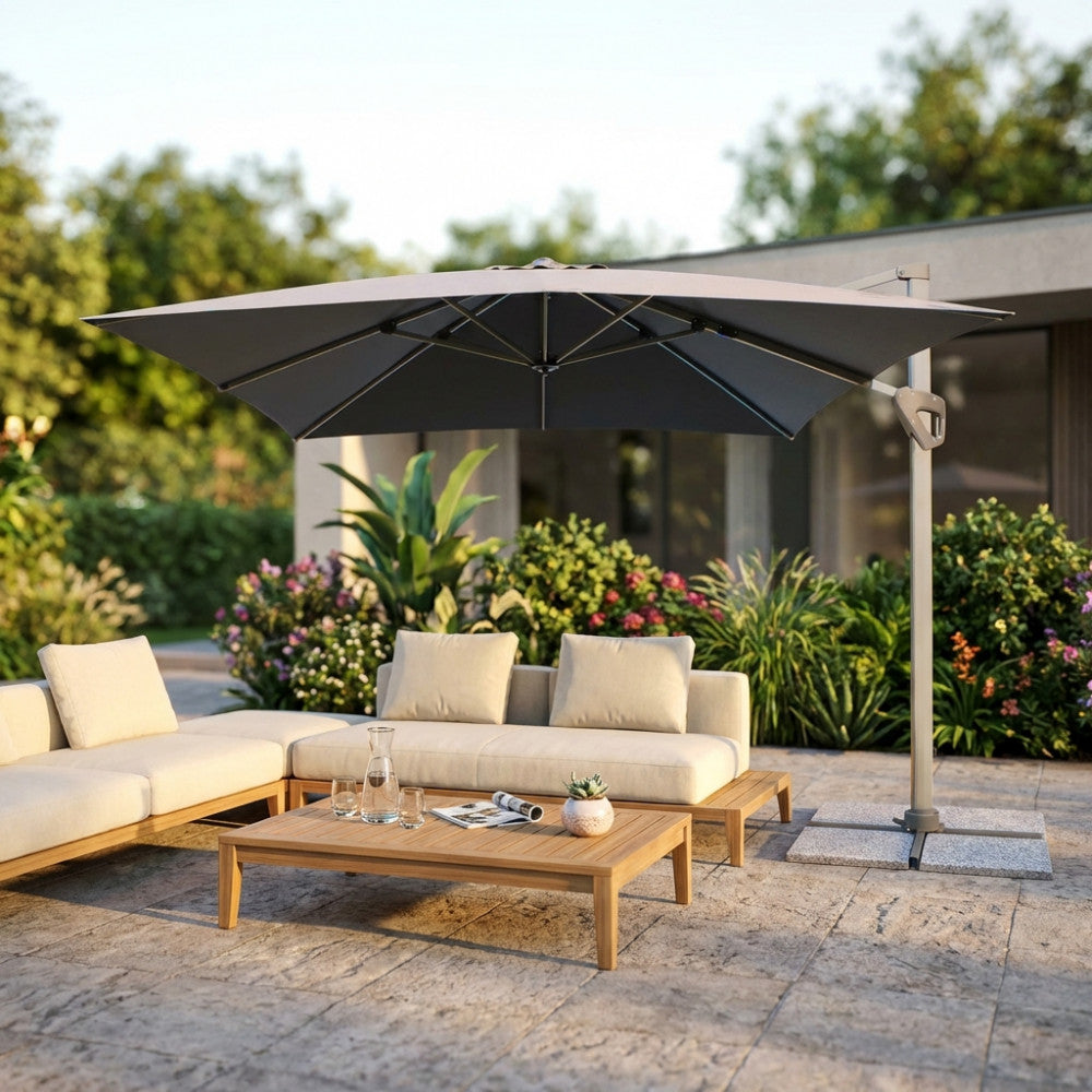 Ombrellone Darwin 3x3 grigio aperto su un patio moderno con divano lounge.