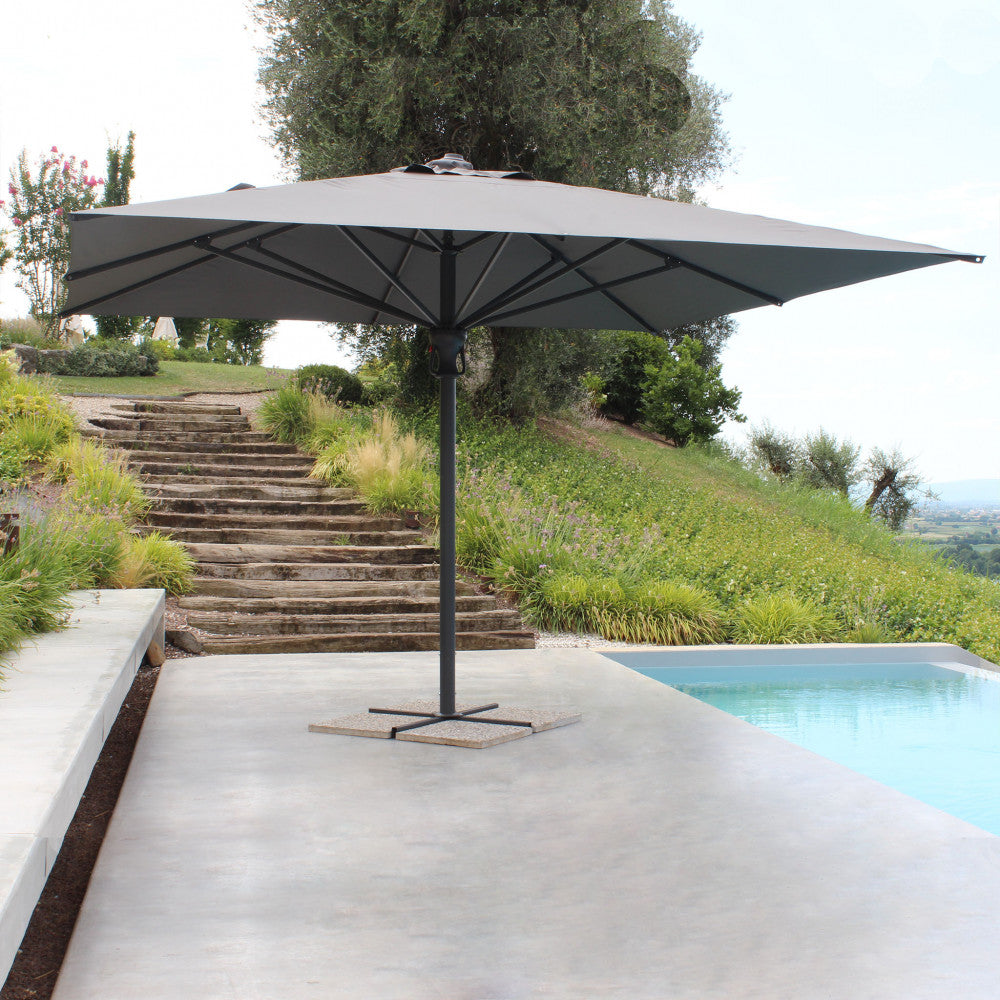 Dettaglio dell'ombrellone Deneb inserito in un giardino terrazzato di design.