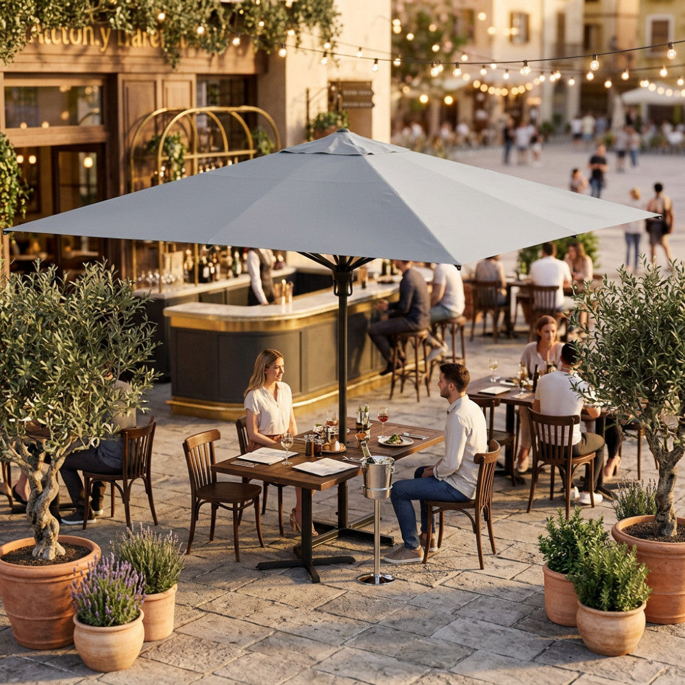 Ombrellone a palo centrale Deneb aperto su un patio di un ristorante all'aperto con tavoli in legno.