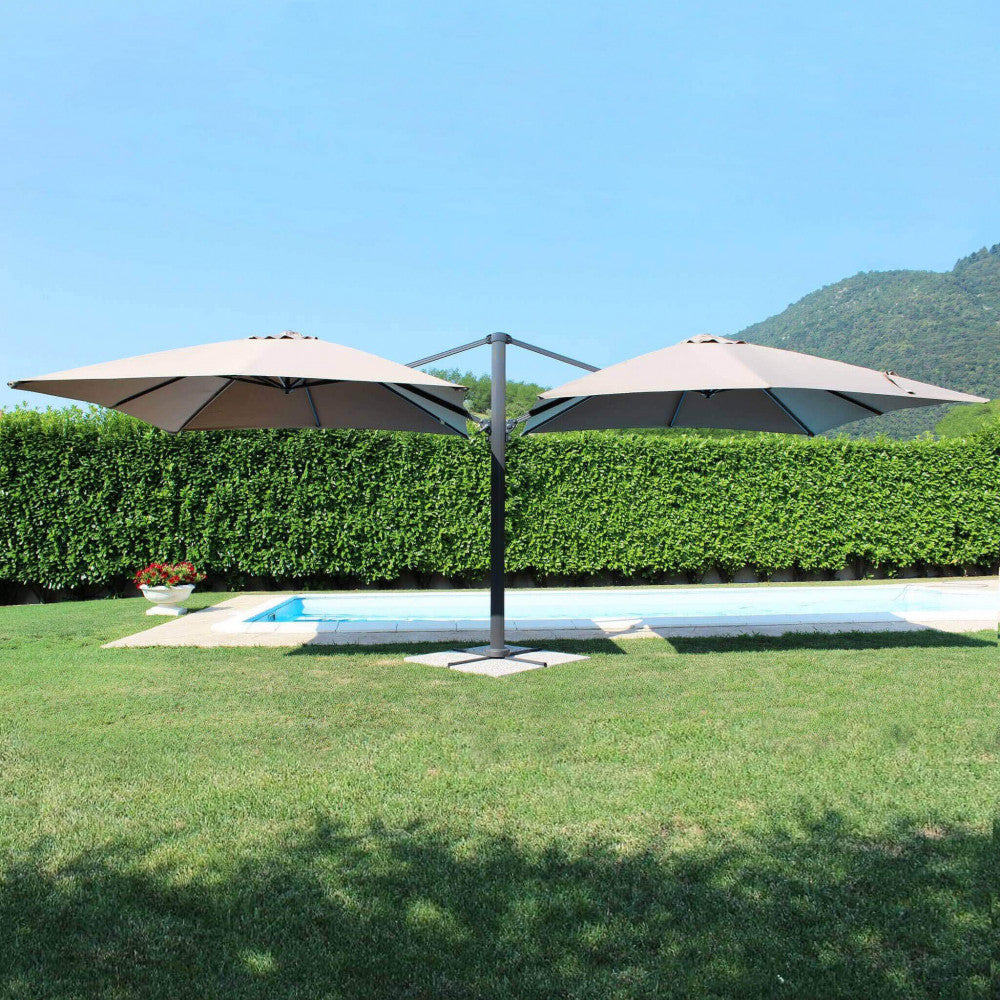 Ombrellone doppio Archimede aperto in un giardino verdeggiante con piscina.