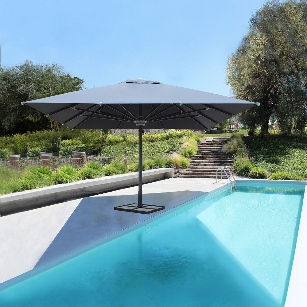 Ombrellone Giove antracite posizionato a bordo piscina in un lussuoso giardino contemporaneo.