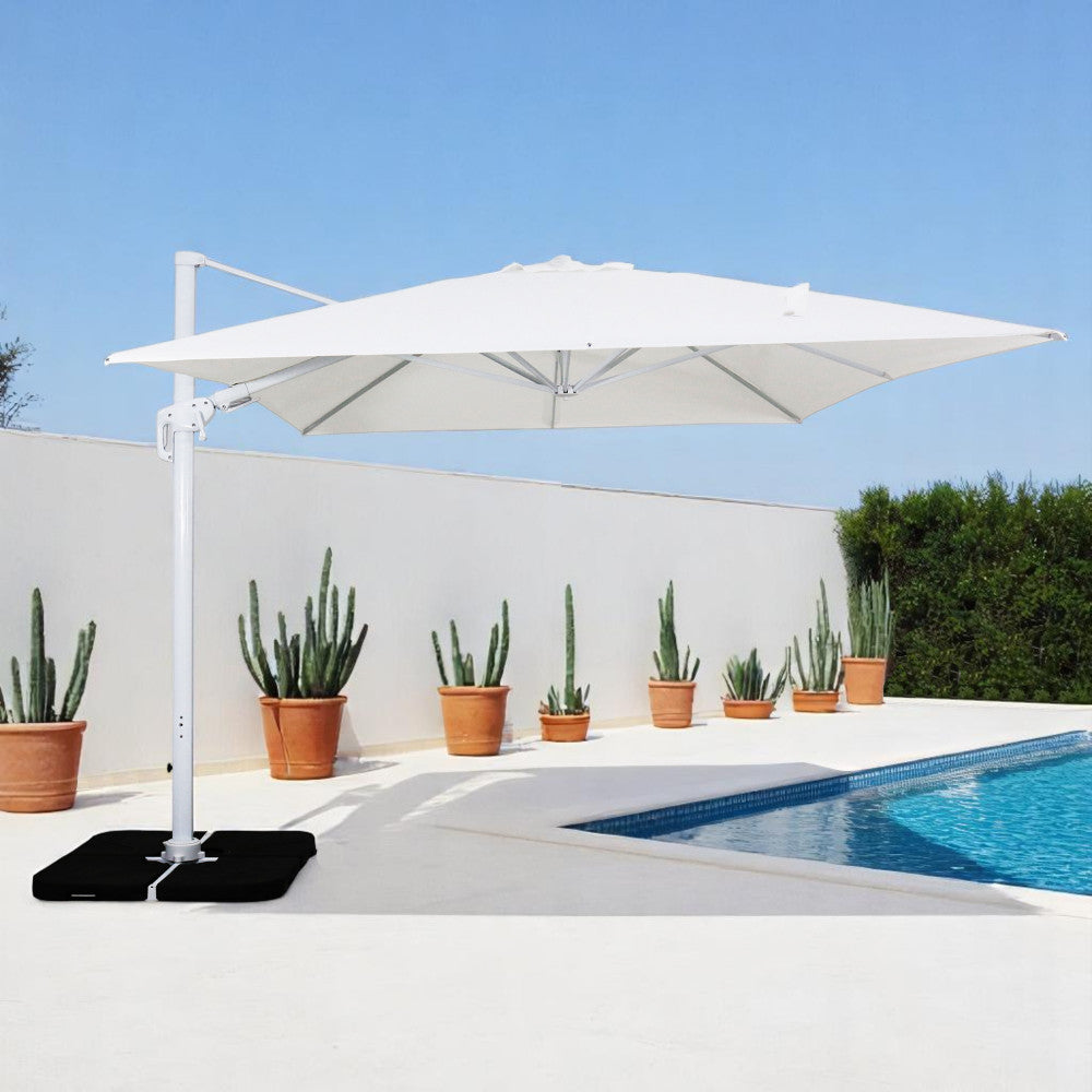 Ombrellone moderno Hamel bianco installato in un patio minimalista con piscina e cactus.