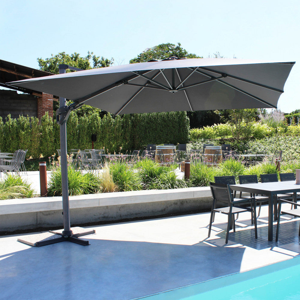 Ombrellone Mendel che copre un'area lounge esterna vicino alla piscina.