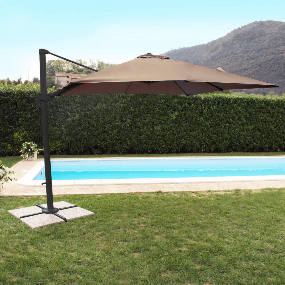 Ombrellone da giardino posizionato a bordo piscina con sfondo di siepi verdi e colline.