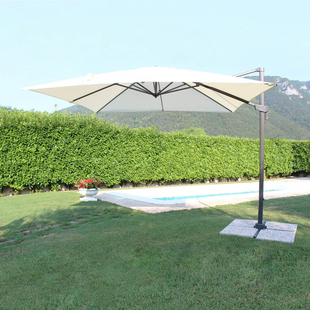 Ombrellone Newton posizionato in un rigoglioso giardino verde, a dimostrazione della sua imponenza architettonica.