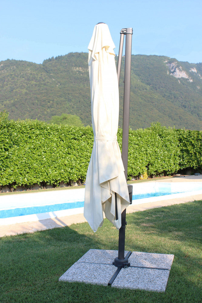Ombrellone Newton chiuso a bordo piscina, mostrando il minimo ingombro della struttura in alluminio nero.