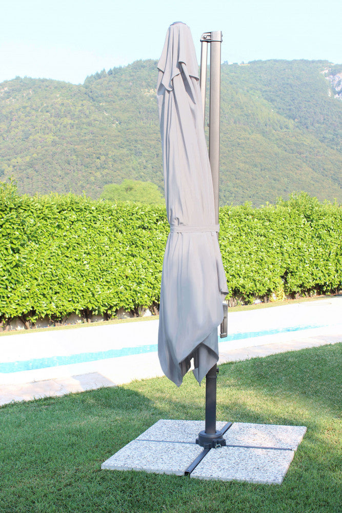 Ombrellone Newton chiuso, con il telo in poliestere grigio ripiegato elegantemente lungo il palo laterale in alluminio.