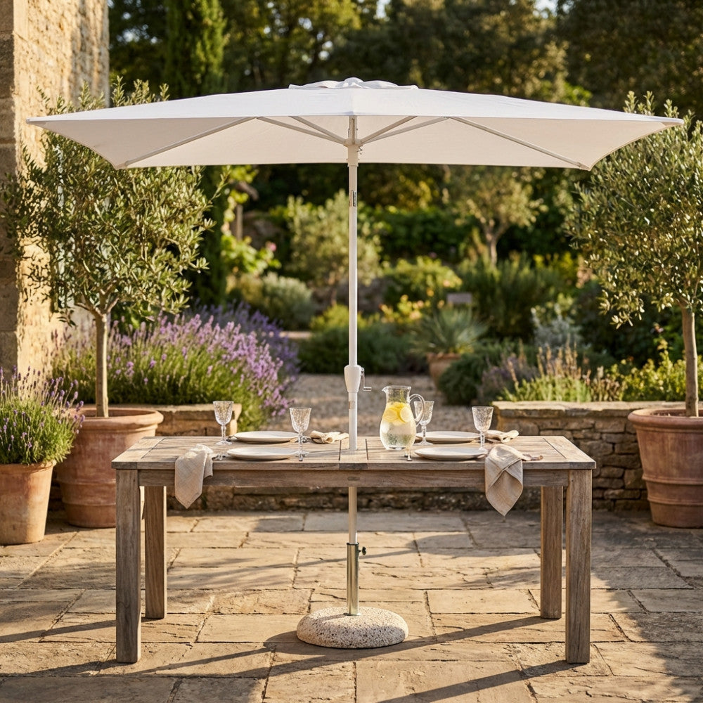 Ombrellone Cosma Poly Eco bianco aperto su un tavolo da giardino