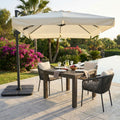Ombrellone a palo laterale Cosma Saturno 3x3 ecrù su tavolo da pranzo esterno