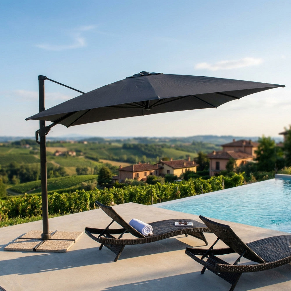 Ombrellone a braccio nero aperto su due lettini prendisole a bordo di una lussuosa piscina a sfioro con vista sulle colline.