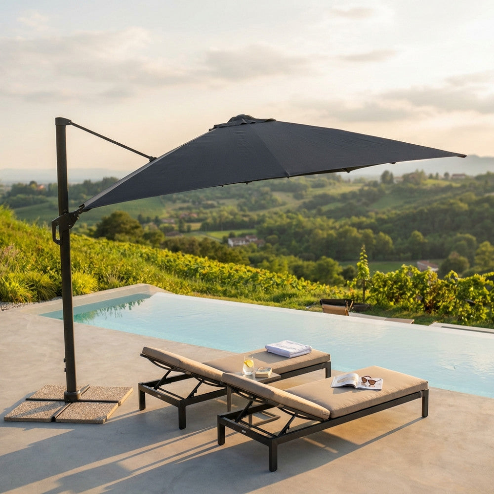 Moderno ombrellone a palo laterale nero che fa ombra ai lettini a bordo piscina in un sereno ambiente esterno.