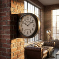Orologio da parete Hector in acciaio antracite installato su una colonna in mattoni rossi in un elegante loft industriale illuminato dalla luce naturale.