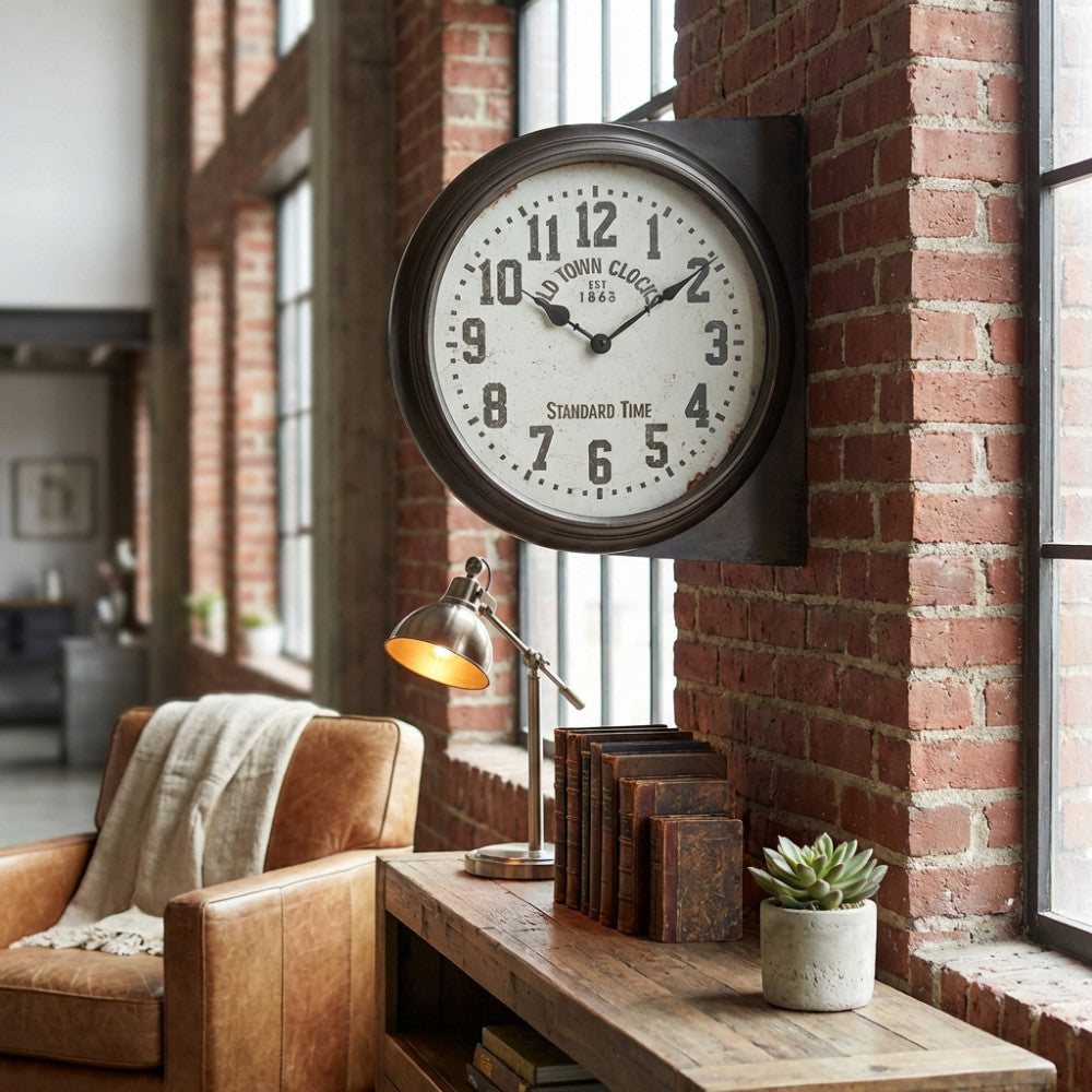 Vista laterale dell'orologio da parete vintage Hector, che mostra la struttura a doppia faccia in metallo scuro sopra una consolle in legno rustico.
