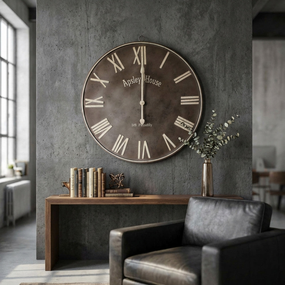 Orologio da parete HUGO in stile industriale posizionato in un salotto moderno con poltrona in pelle scura.