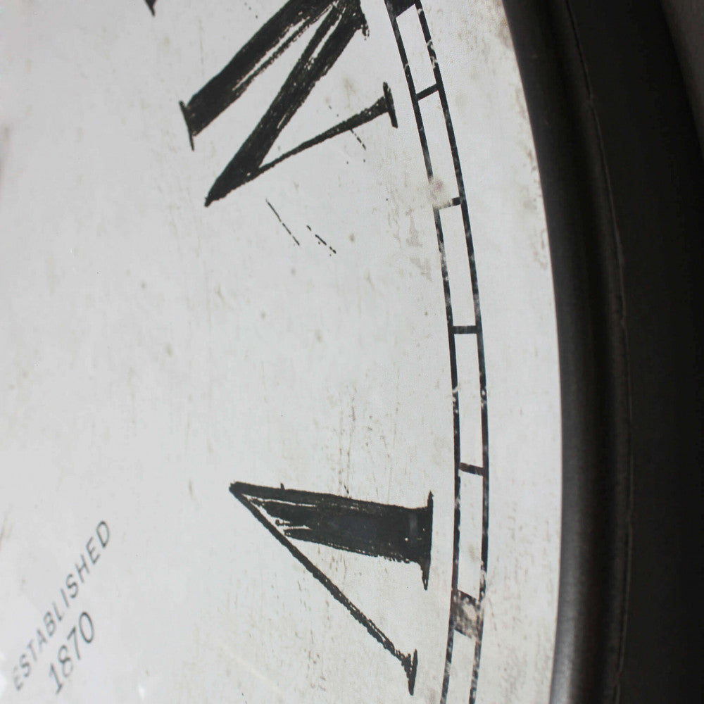 Primo piano del quadrante in vetro e acciaio dell'orologio, che mostra i dettagli dei numeri romani stampati e l'effetto invecchiato.