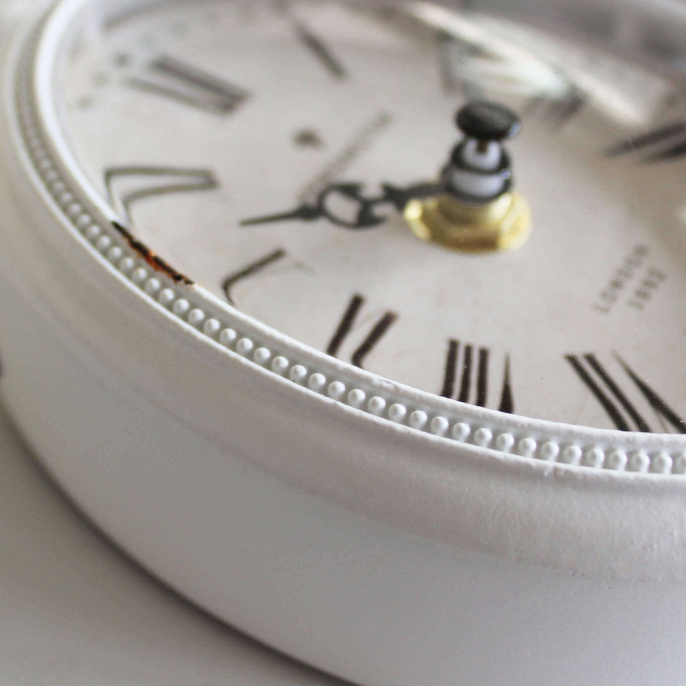 Particolare della cornice in acciaio bianco anticato dell'orologio Cosma