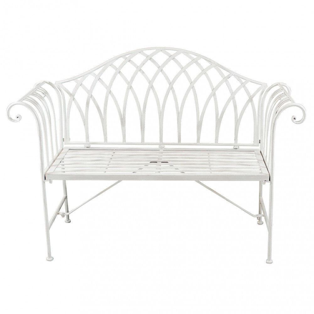 Panca Annette in metallo verniciato a polvere colore bianco antico, posizionata in un giardino.