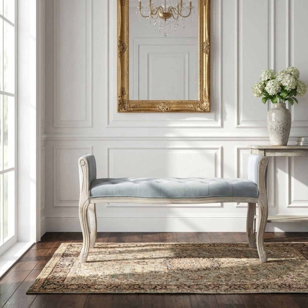 Panca Madelyn elegantemente inserita in un ingresso con specchio dorato e pareti con boiserie bianca.